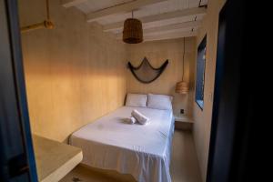 a small bed in a small room with at Hostel Tainha Caraíva in Caraíva