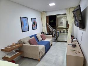 a living room with a couch and a tv at Conforto e Sofisticação à Beira Mar in Cabedelo