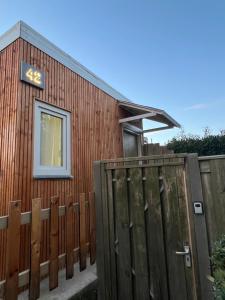 ein Holzhaus mit einem Zaun und einem Fenster in der Unterkunft Wangwang house in Heerlen