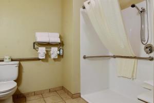 a bathroom with a shower and a toilet and towels at Cobblestone Inn & Suites - Carrington in Carrington +25 photos