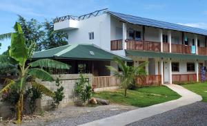 a white building with a green roof at Dani's Guesthouse in Las Galeras