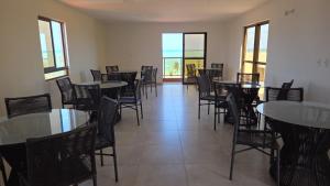 a dining room with tables and chairs and windows at Conforto e Sofisticação à Beira Mar in Cabedelo