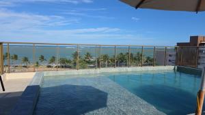 a swimming pool with a view of the ocean at Conforto e Sofisticação à Beira Mar in Cabedelo