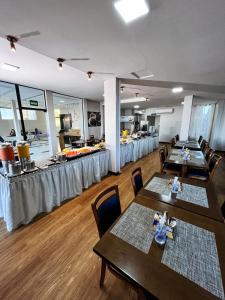 a restaurant with tables and chairs and a kitchen at Citi Executivo Hotel in Parnaíba