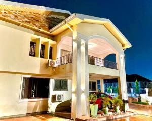 a large white house with a balcony at 3R Haven in Kumasi