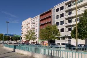 a city street with buildings and a blue fence at Center Gardens Apartments in Lisbon