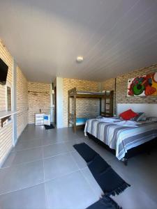 a bedroom with a bed and a brick wall at Pousada Manga Azul in Barra de Camaratuba