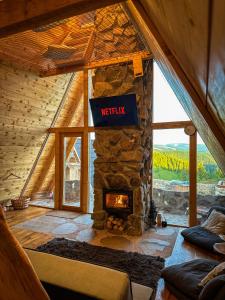 a living room with a stone fireplace in a house at Cabana Balu in Măguri