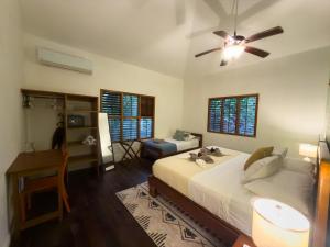 a bedroom with a bed and a ceiling fan at Conchy Tonk in Bocas Town