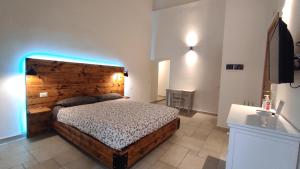 a bedroom with a large bed with a wooden headboard at ''B&B Santa Rita Corato fitta camere'' in Corato