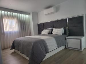 a bedroom with a large bed with a large headboard at Casa do Azeite in Torre de Moncorvo