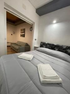 a bedroom with a bed with two towels on it at Luma Sixty nine in Alcamo