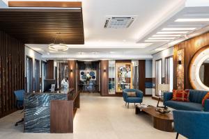 a hotel lobby with a reception desk and blue chairs at Shalom Suites by Yellowkey in Santo Domingo +156 photos