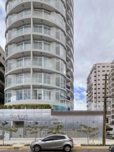 a car parked in front of a tall building at Shalom Suites by Yellowkey in Santo Domingo