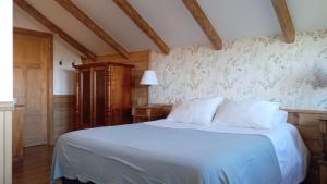 a bedroom with a bed with white sheets and floral wallpaper at Hotel Boutique Casa Werner in Puerto Varas