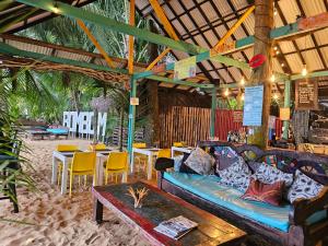 a living room with a couch and tables and chairs at Conchy Tonk in Bocas Town
