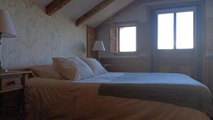 a bedroom with a bed and two windows at Hotel Boutique Casa Werner in Puerto Varas