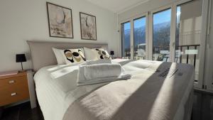 a bedroom with a large bed with white sheets and pillows at Center Park Apartment in Interlaken