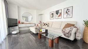 a living room with a white couch and a mirror at Center Park Apartment in Interlaken