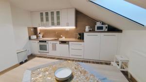 a kitchen with white cabinets and a sink at Apartmán Altis in Tatranska Strba