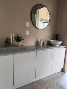 a white bathroom with a sink and a mirror at FelTix container loft in Sabakoe +24 photos