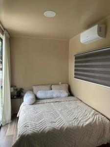 a bedroom with a bed and a air conditioner at FelTix container loft in Sabakoe