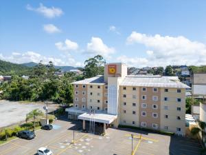 a building with a clock tower on top of a parking lot at Hotel 10 Blumenau in Blumenau