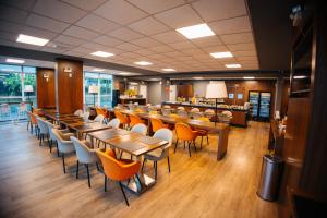 a restaurant with tables and chairs and a bar at Hotel 10 Blumenau in Blumenau