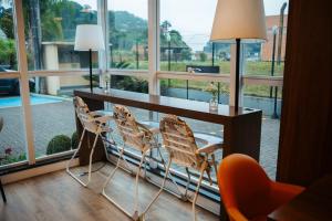 a table and chairs in a room with a large window at Hotel 10 Blumenau in Blumenau