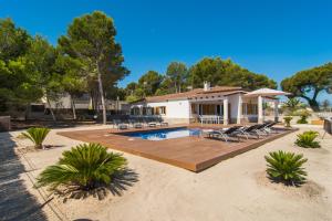 a house with a pool and a deck with chairs at Villa Anglesos in Can Picafort