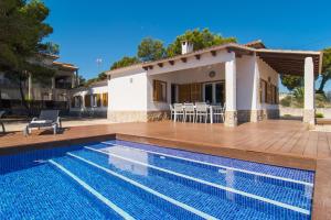 a villa with a swimming pool and a house at Villa Anglesos in Can Picafort