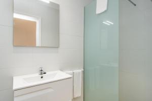 a white bathroom with a sink and a mirror at Villa Anglesos in Can Picafort +37 photos
