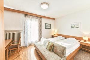 a hotel room with a bed and a couch at Hotel Gasthof Stern in Nova Ponente