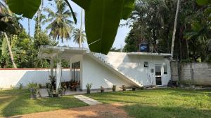 a white house with a staircase leading up to it at Hideaway in Bentota