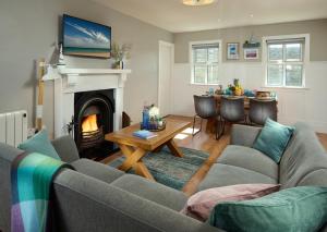 a living room with a couch and a fireplace at Armada Cottages in Spanish Point