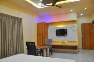 a room with a table and a tv on a wall at Hotel Shivar in Kalam +18 photos