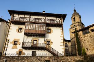 a building with a balcony and a tower at Palacio Soran in Leintz-Gatzaga