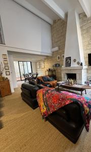 a living room with black leather furniture and a fireplace at Chez Marie & Nico in Aigues-Mortes