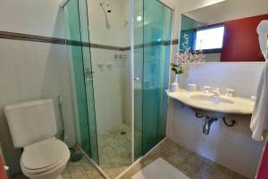 a bathroom with a shower and a toilet and a sink at Pousada Tiê Sahy in Barra do Sahy +33 photos