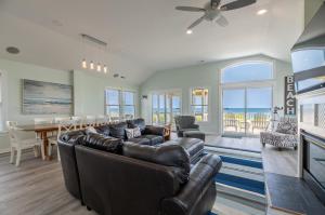 a living room with a couch and a dining room at Savannah - Nags Head MP 16, Oceanfront, Direct Beach Access, Pool, Hot Tub, Pool Table in Nags Head