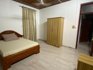 a bedroom with a bed and a wooden cabinet at Coastal Retreat Penthouse in Pereybere