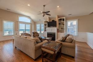 a living room with two couches and a fireplace at Hidden Treasure - Nags Head MP 16, Oceanfront, Private Beach Access, Pool, Hot Tub, Pool Table, Pets OK in Nags Head
