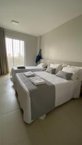 two beds in a white bedroom with a large window at Dom Carlos in Belém