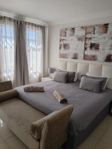 a bedroom with a large bed and a couch at Stadium Apartment in Cape Town