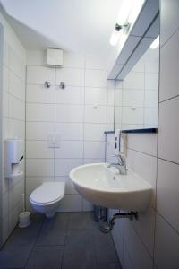 a white bathroom with a sink and a toilet at Hotel Transit Loft in Berlin