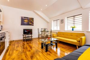 a living room with a yellow couch and a tv at Exclusive Apartment in Newcastle upon Tyne