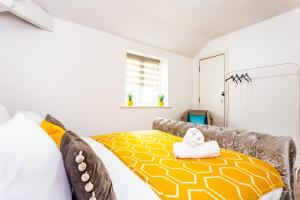 a bedroom with a couch with a yellow and white bed at Exclusive Apartment in Newcastle upon Tyne