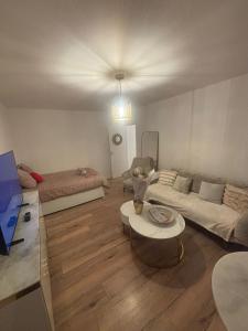 a living room with a couch and a table at Le Cocon - Paris - Netflix - Parking in Noisy-le-Grand +7 photos