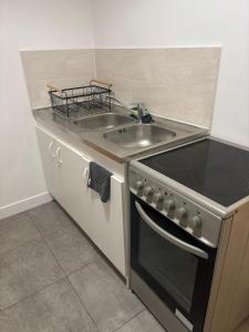 a kitchen with a sink and a stove at Le Cocon - Paris - Netflix - Parking in Noisy-le-Grand