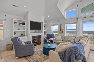 a living room with two couches and a fireplace at Atlantic Watch in Kill Devil Hills